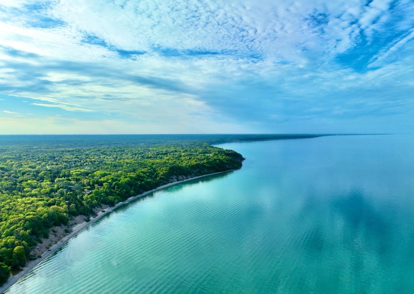 An aerial view of Lake Michigan and its wooded shoreline